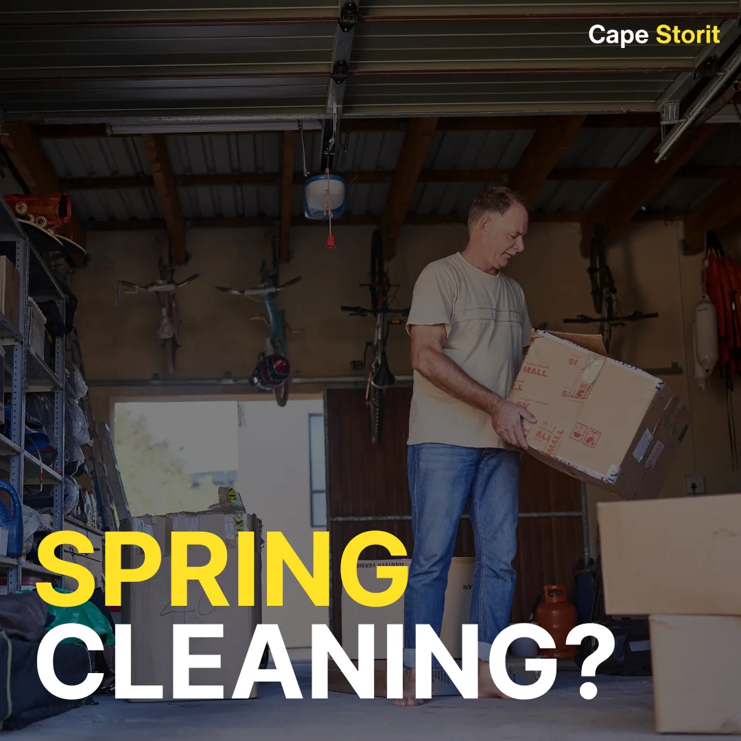 Man carrying a box while clearing out a garage