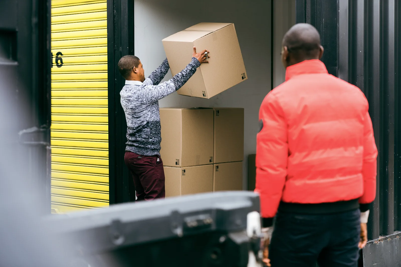 Customers loading boxes from a trailer into a storage unit at Cape Storit Paarden Eiland