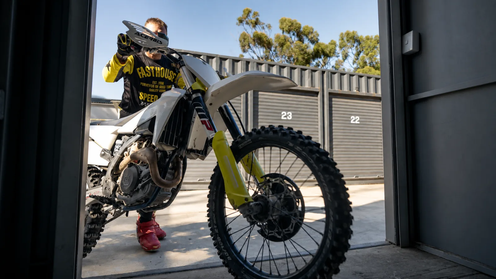 Rider wheeling a motocross bike out of a Cape Storit storage container at Zone 7