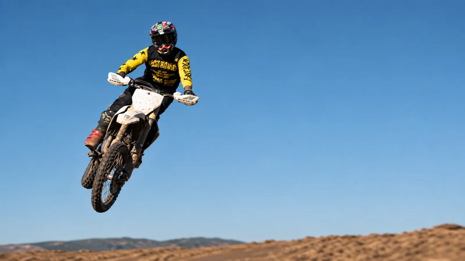 Motocross rider mid-jump — Cape Storit stores bikes trackside at Zone 7