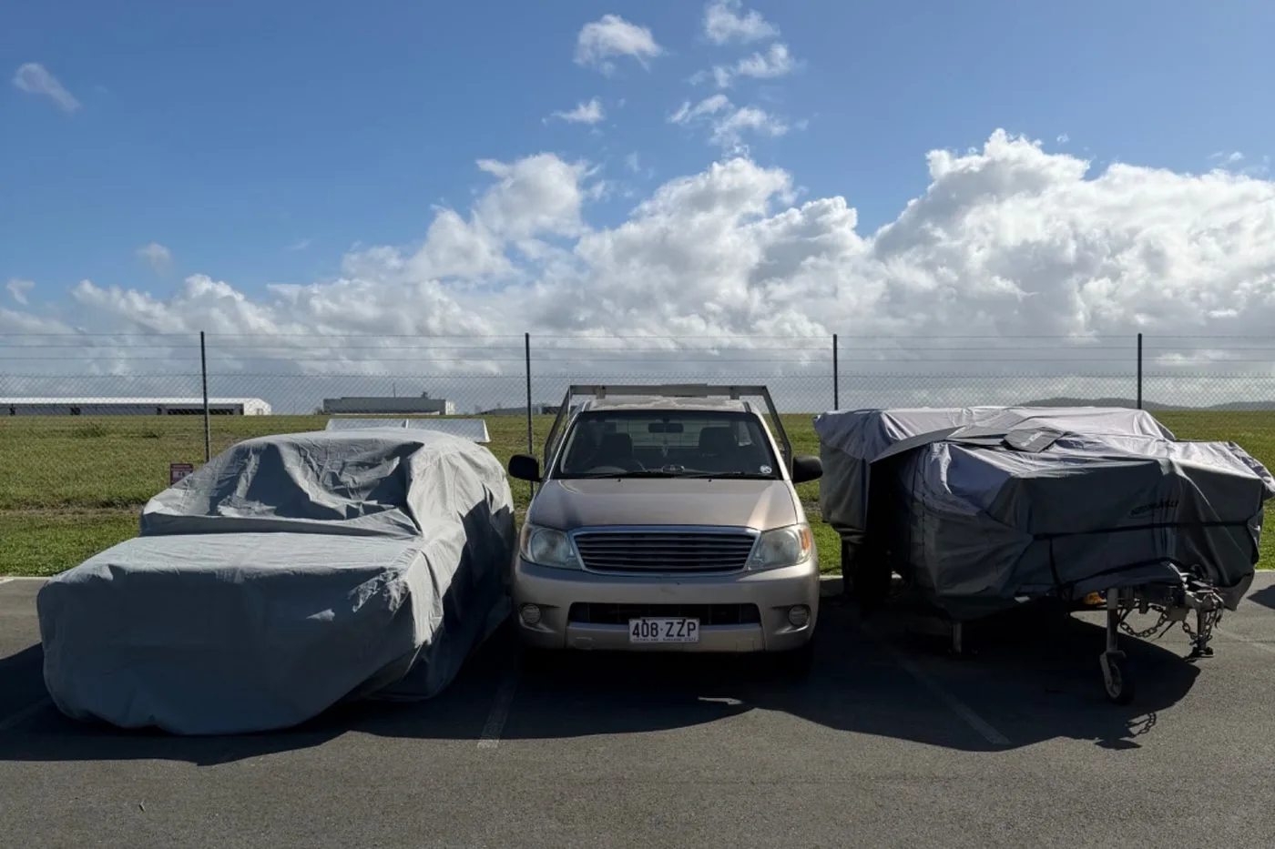 Covered vehicles and trailers parked in secure open-air storage bays at Storage Land, Archerfield Brisbane