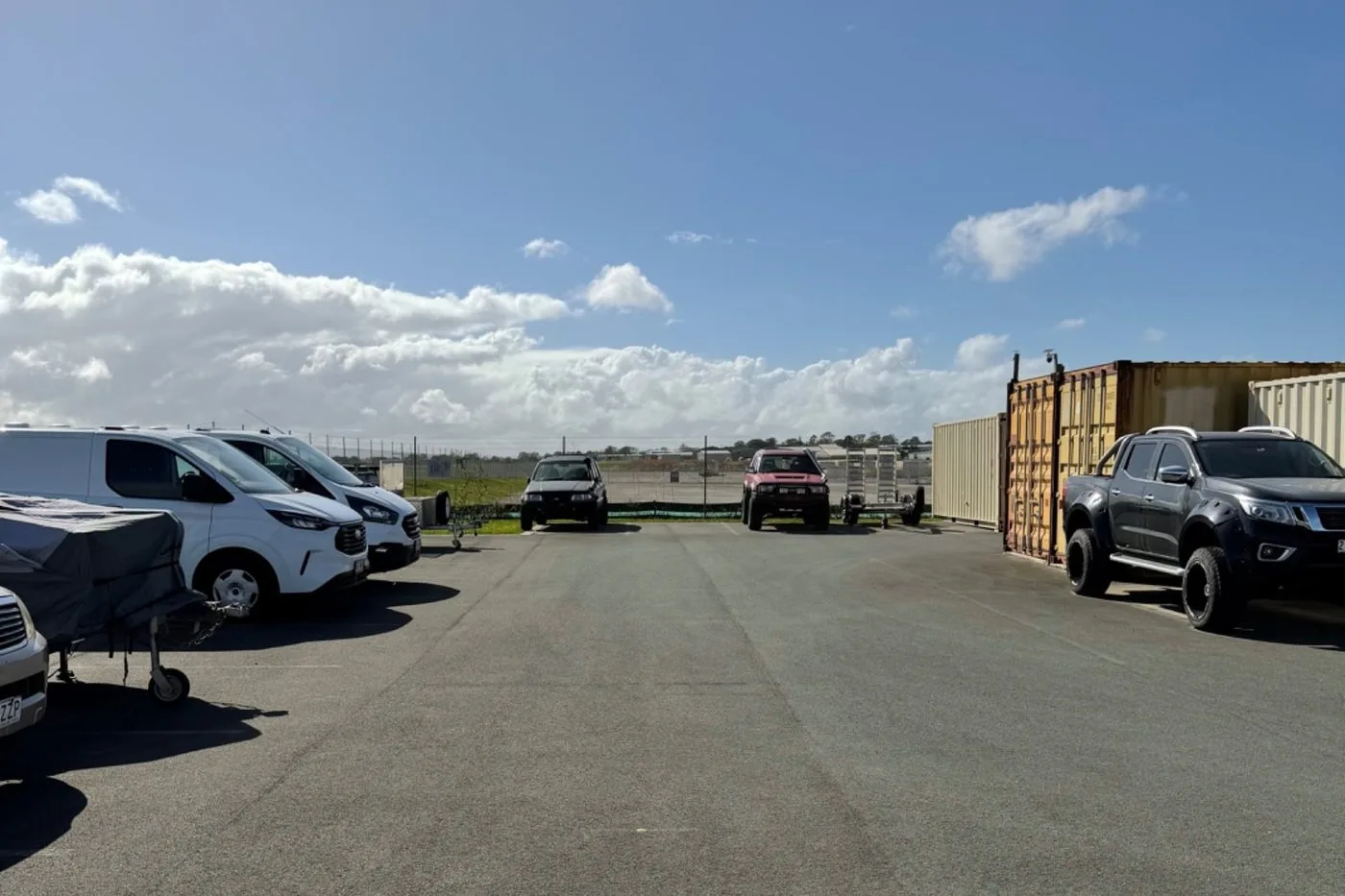 Cars, utes and vans parked in open-air vehicle storage bays on the sealed bitumen yard at Storage Land, Archerfield Brisbane